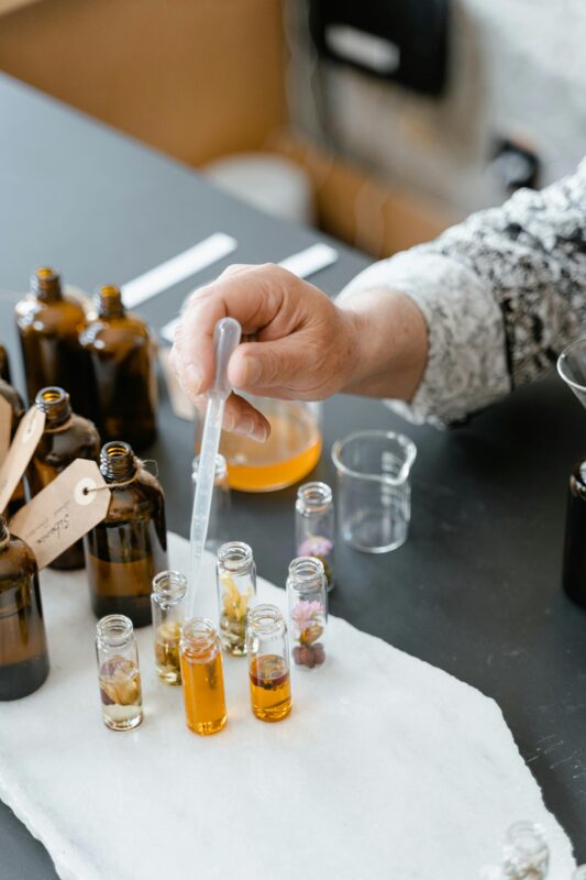The Aromatic Legacy of Al Badar Attar: A Deep Dive into Tradition, Fragrance, and Spiritual Essence 5 A person blending various natural essential oils in small bottles for aromatherapy.